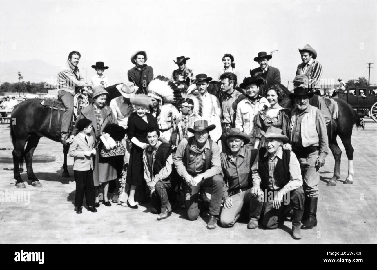 CLINT EASTWOOD in group photo circa 1963 candid at the time he was appearing in the TV series RAWHIDE at a cowboy / western show for disabled children with CLU GULAGER on horse at far left Stock Photo