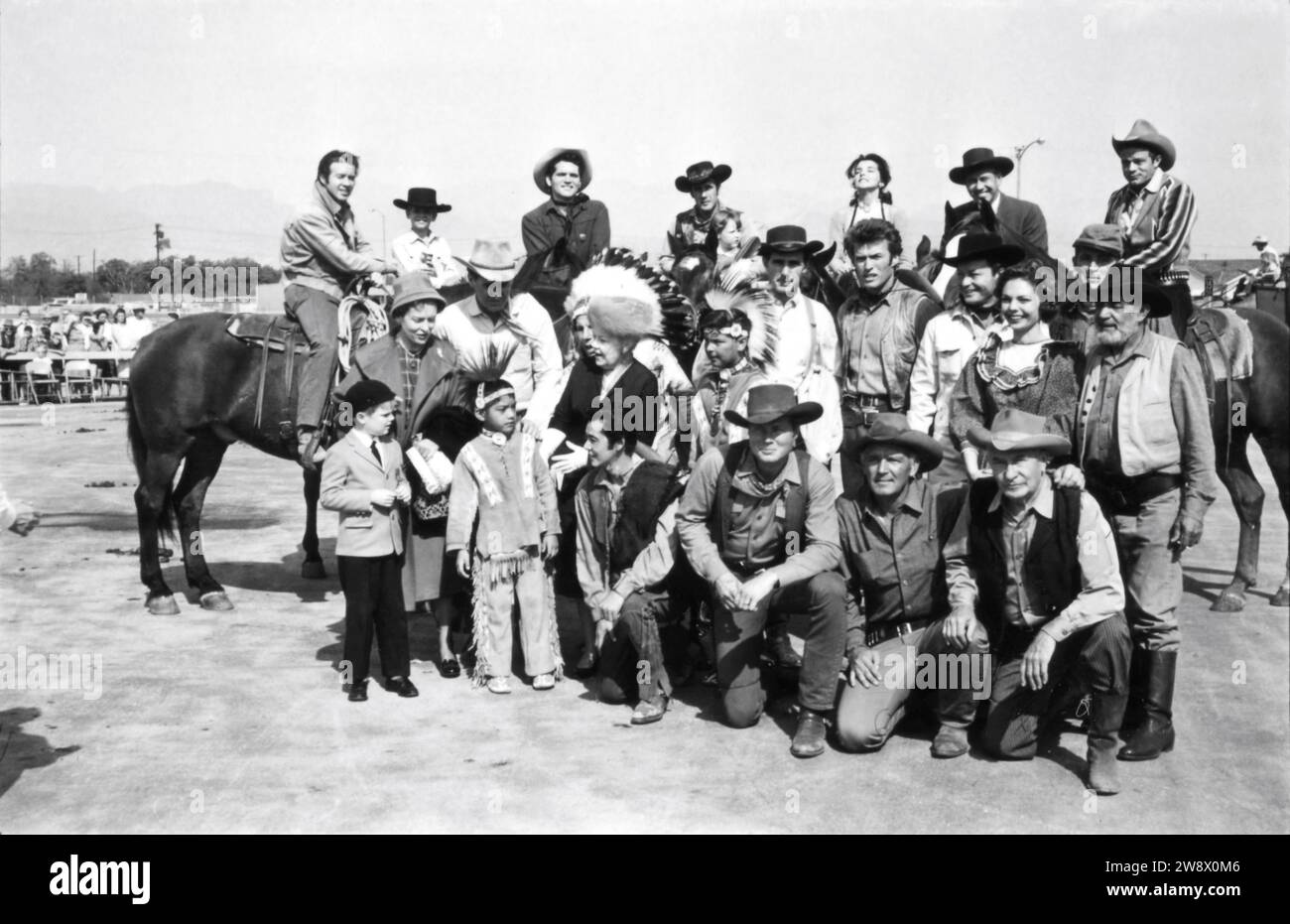 CLINT EASTWOOD in group photo circa 1963 candid at the time he was appearing in the TV series RAWHIDE at a cowboy / western show for disabled children with CLU GULAGER on horse at far left Stock Photo
