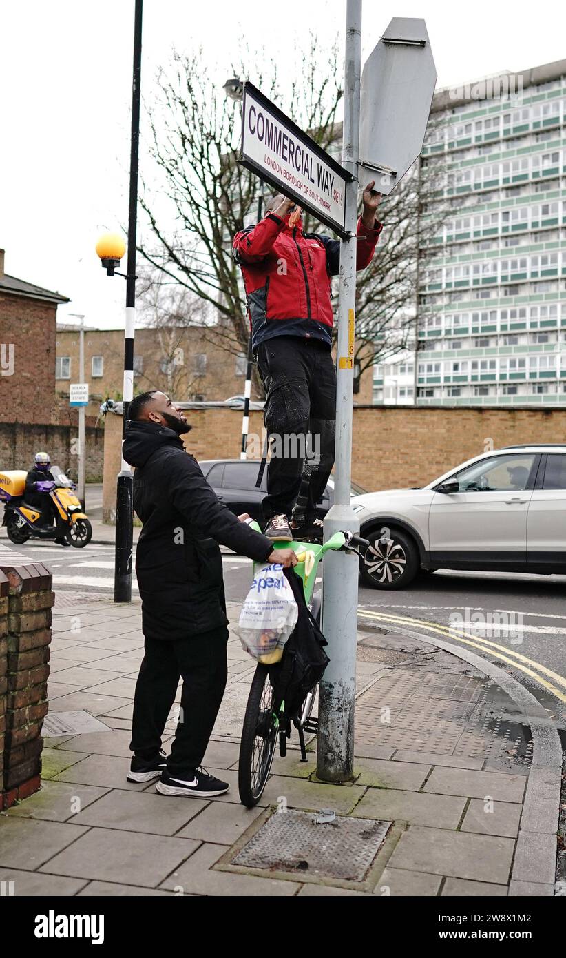 People remove a piece of art work by Banksy, which shows what looks
