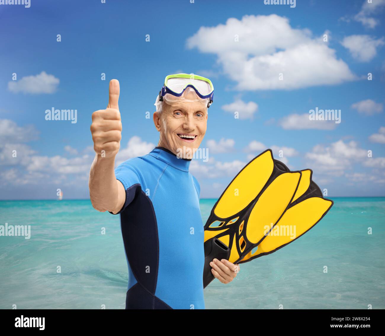 Senior man with snorkeling equipment making a thumb up sign by the sea Stock Photo