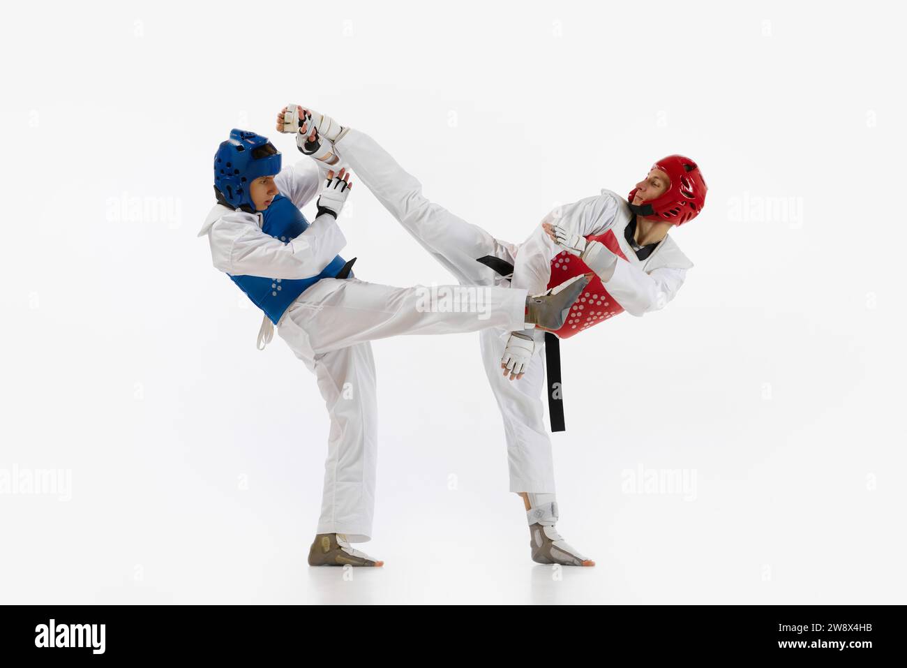 Athletic, motivated young men, taekwondo athletes in motion, practicing ...