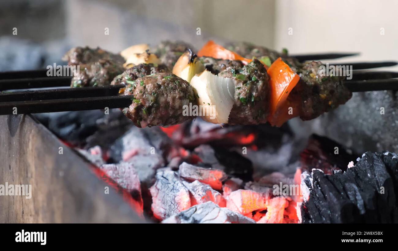 Smoky Grilled meat in skewers on hot coals - Charcoal grilled meat on skewers - skewers grilled goods Stock Photo