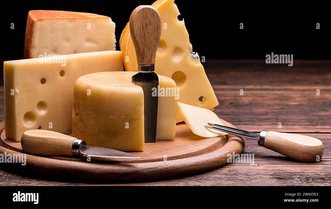 Italian Cheese Food Platter - Skillfully arranged sliced cheese blocks - Gourmet Italian cheese on the tabletop, variety of cheeses beautifully paired Stock Photo