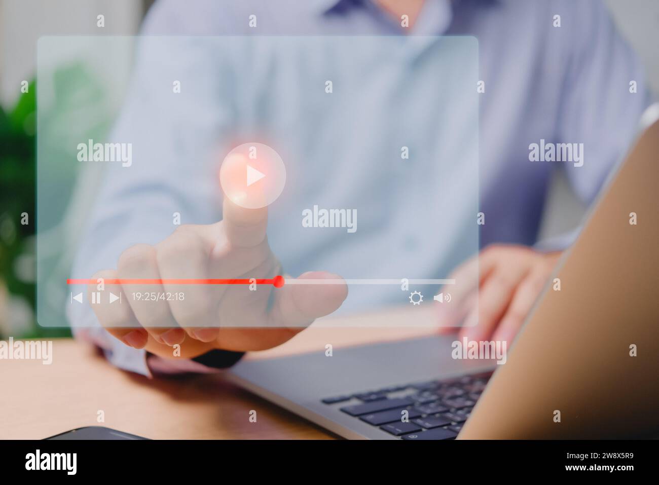 Man streaming live content on virtual screen via laptop for online concerts, shows, tutorials, and multimedia playback. Stock Photo