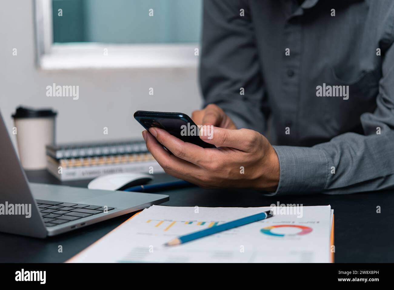 man using  mobile smartphone working and digital online computer laptop at office Stock Photo