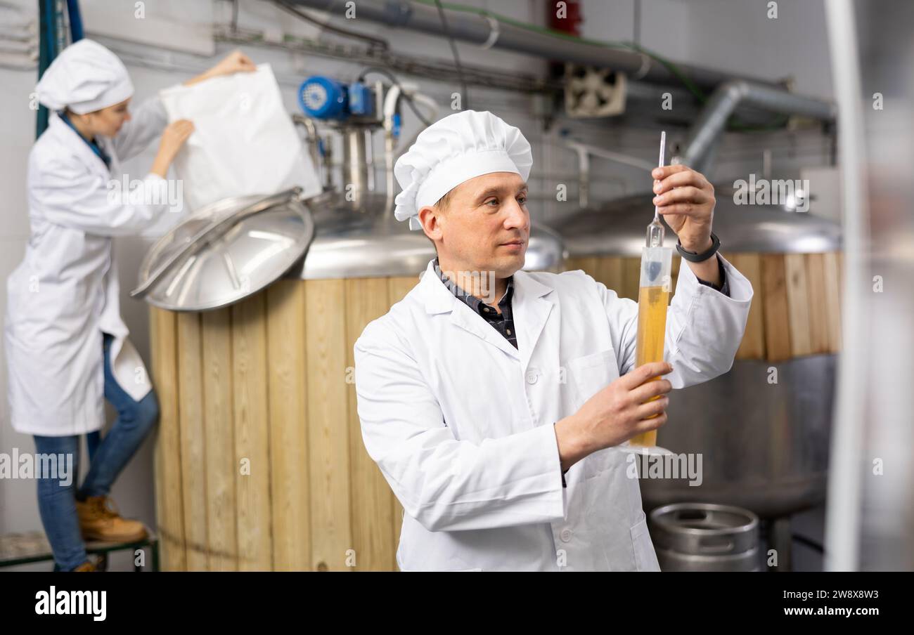 Man brewer indicating alcoholic strength of beer Stock Photo Alamy