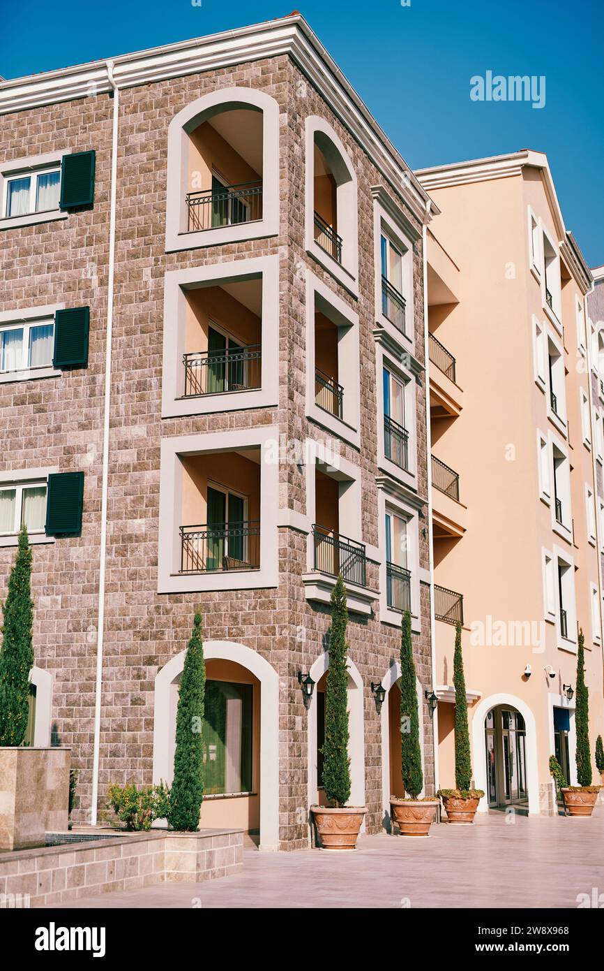 Picture Idea: Green Trees In Clay Pots Grow Near An Apartment Building