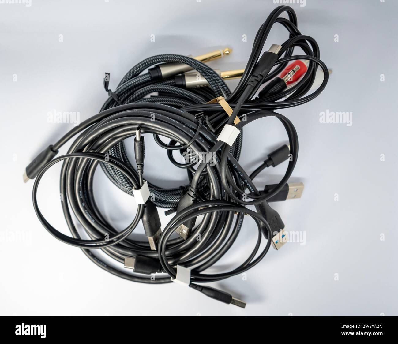 Different types of black cables tangled together Stock Photo - Alamy