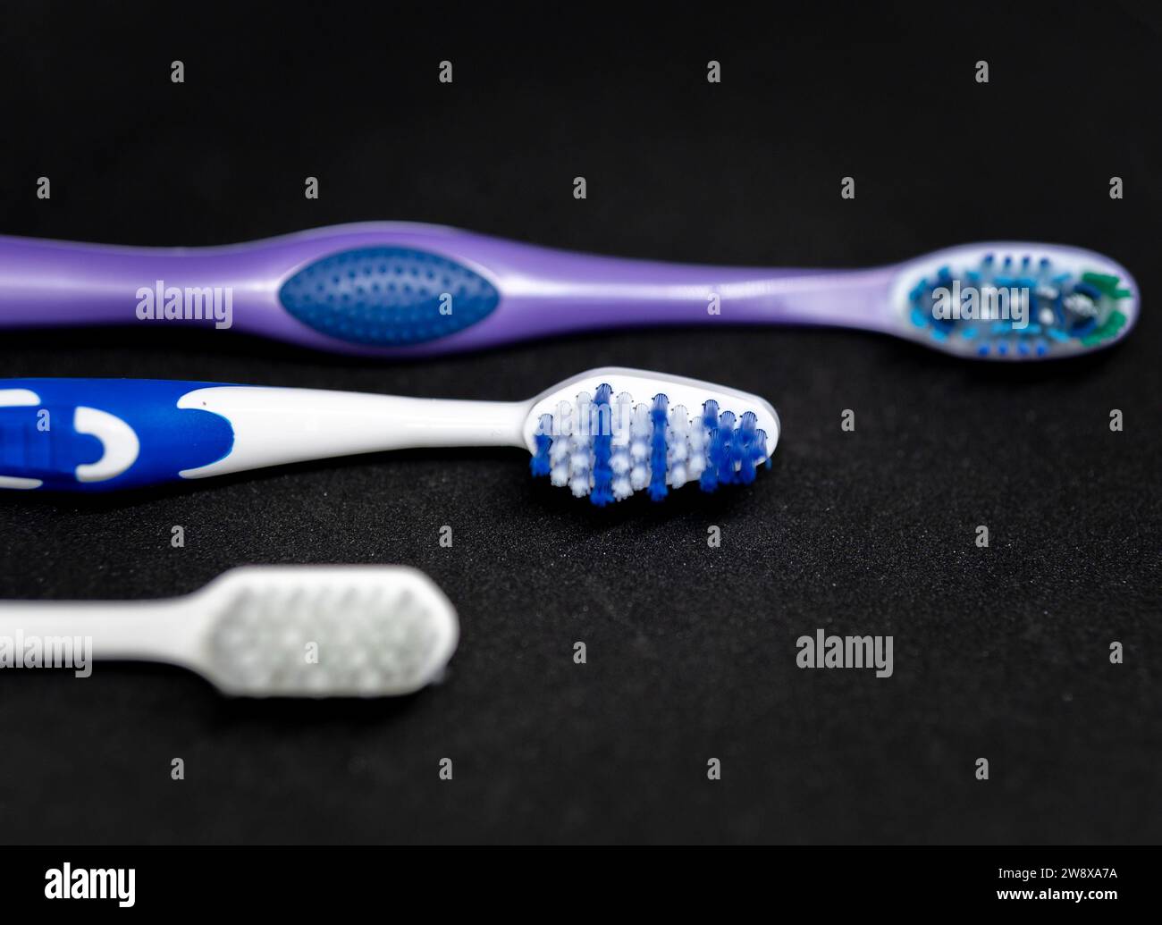 Three toothbrushes of different color Stock Photo Alamy