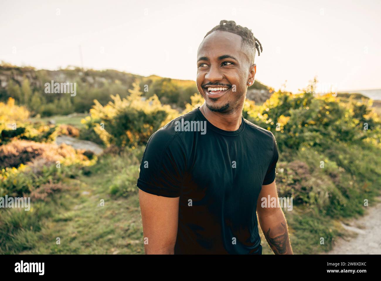 Happy young man looking away at beach Stock Photo