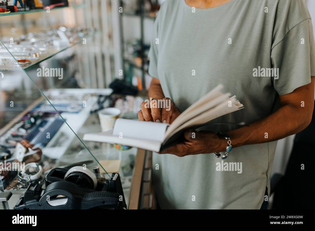 Midsection of saleswoman with diary standing at antique shop Stock Photo