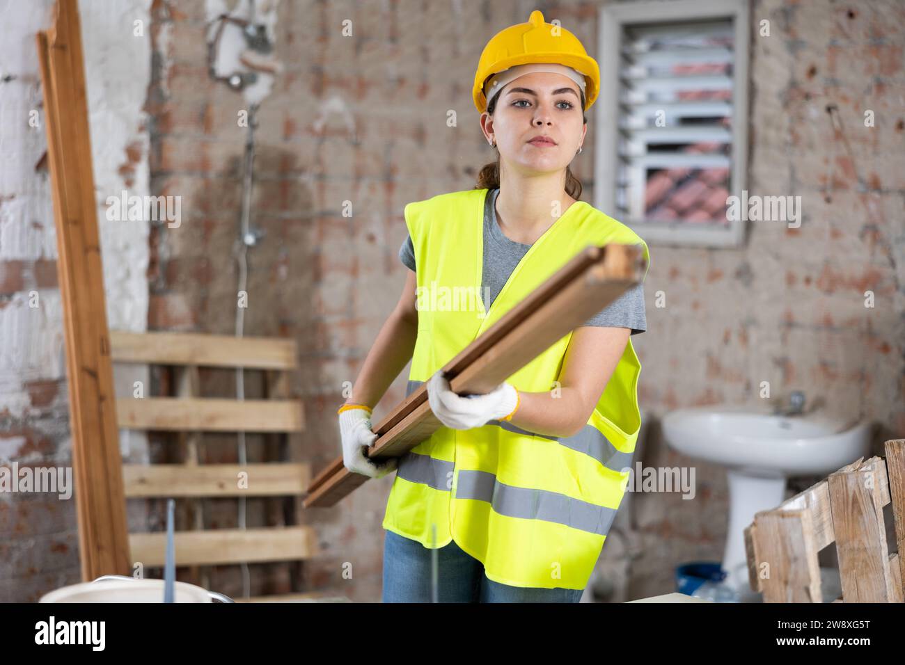 Female carrying wooden panel on construction site Stock Photo