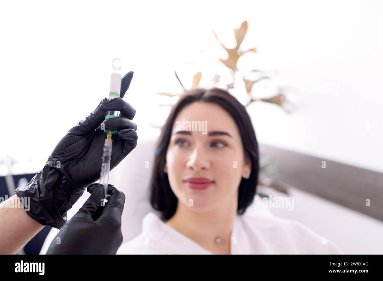 Careful young woman doctor holding injector performing mesotherapy of