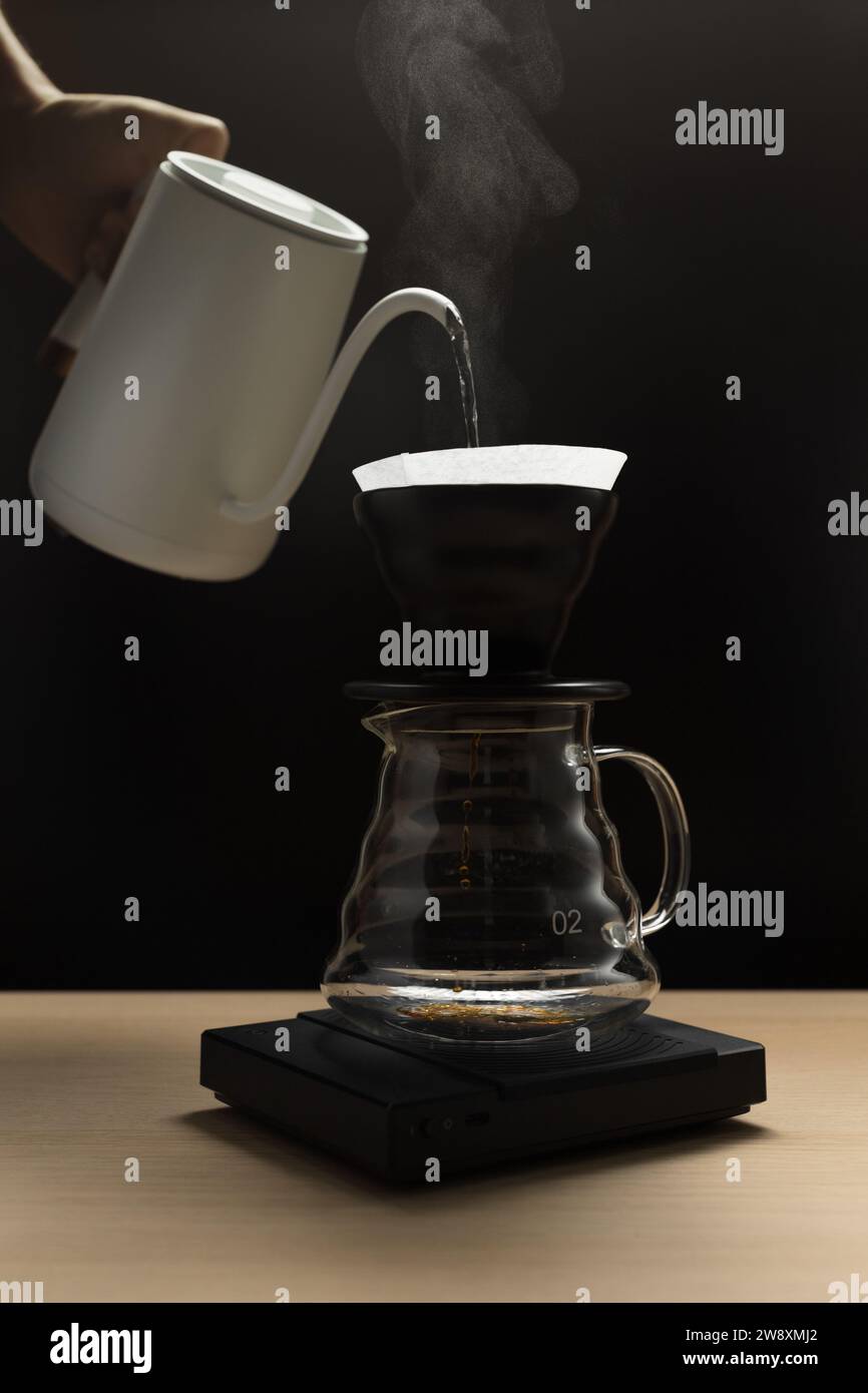 Pouring hot water through coffee grounds in a filter Stock Photo
