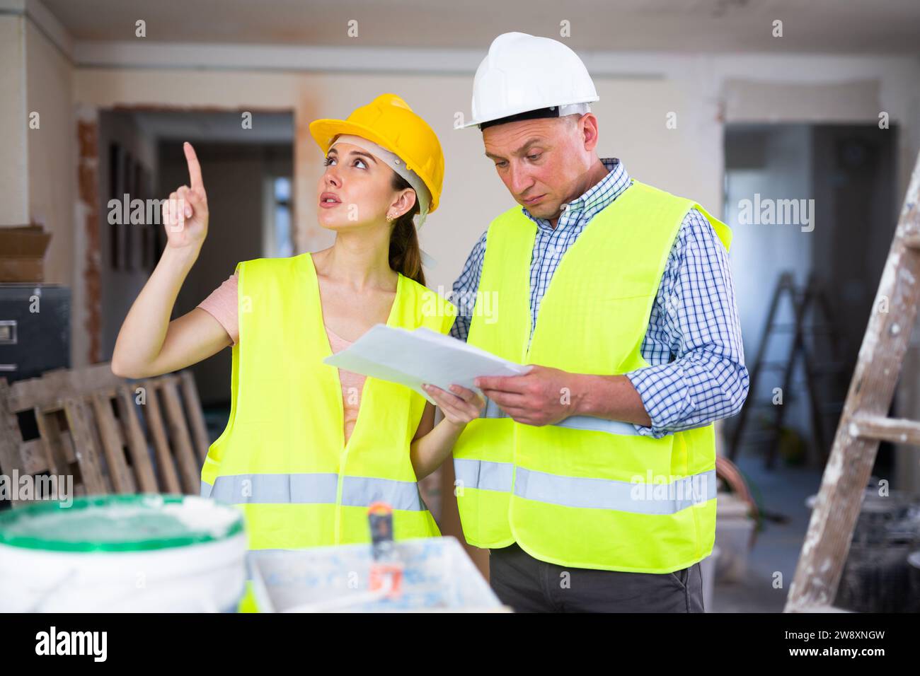 Woman and man repairers talking about documentation Stock Photo