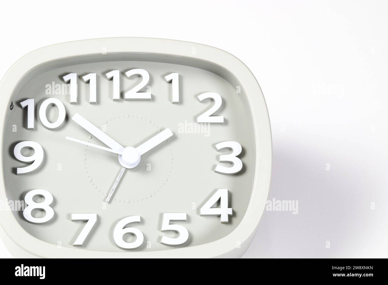 Cheap gray quartz alarm clock isolated on white background. Stock Photo