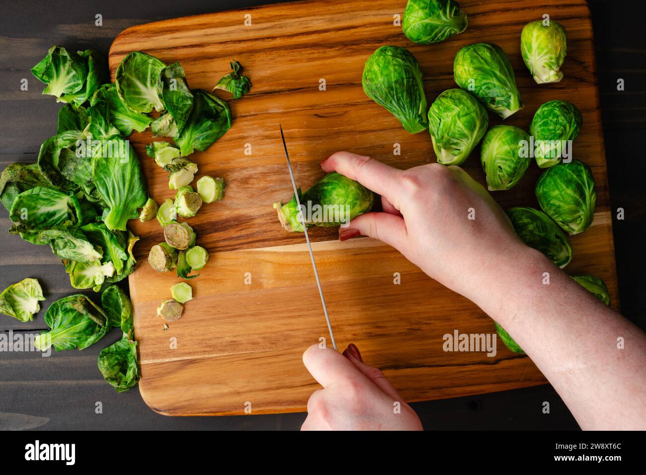 Hands Preparing Raw Brussels Sprouts with a Chef's Knife Chef's hands