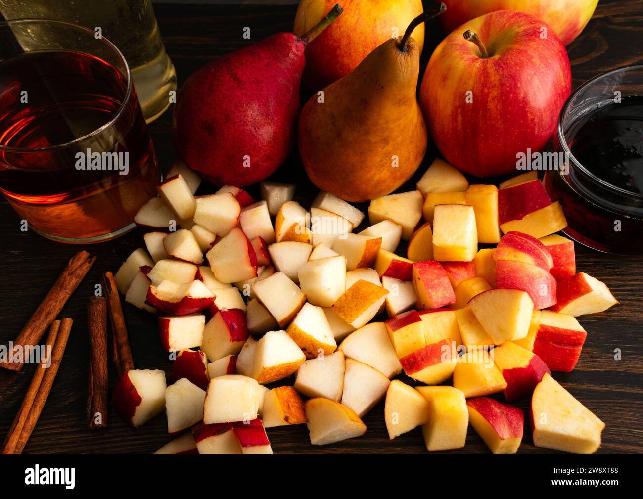 Chopped Bosc Pears, Red Anjou Pears, and Honey Crisp Apples: Chopped fruit with by whole pears and apples, cinnamon sticks, bourbon, and maple syrup Stock Photo