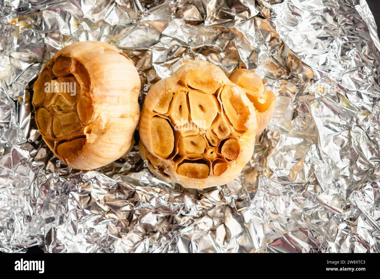 Roasted Heads of Garlic on Crumpled Aluminum Foil Roasted garlic bulbs