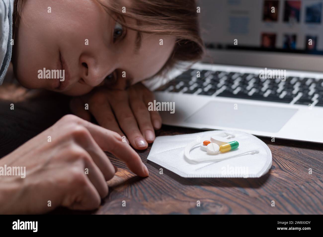 Image of a young girl looking at a handful of antidepressants. The concept of psychological disorders in teenagers due to social networks. Mixed media Stock Photo