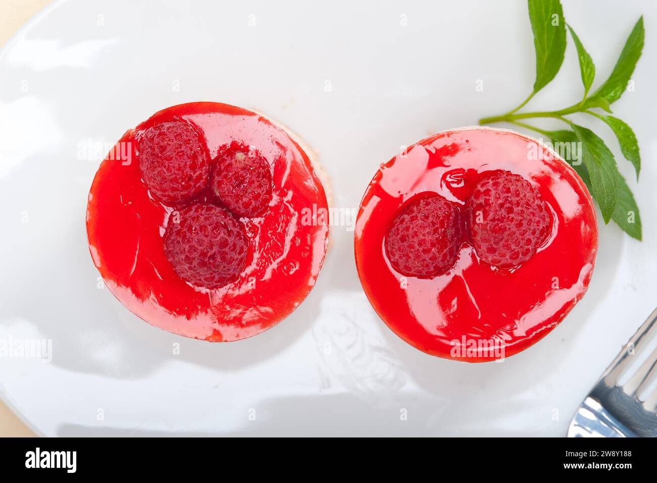 Fresh raspberry cake mousse dessert round shape with mint leaves, food ...