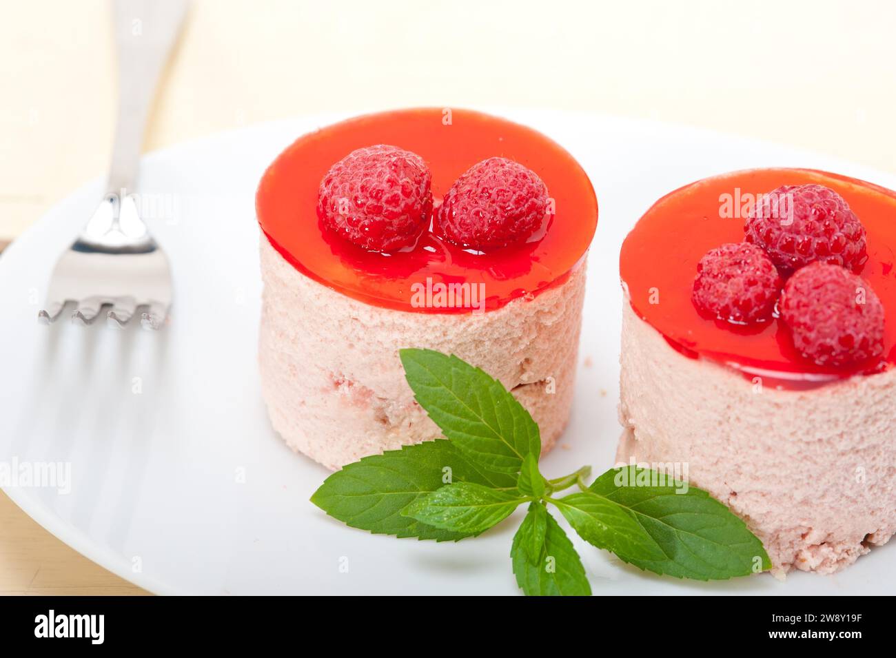 Fresh raspberry cake mousse dessert round shape with mint leaves, food photography Stock Photo