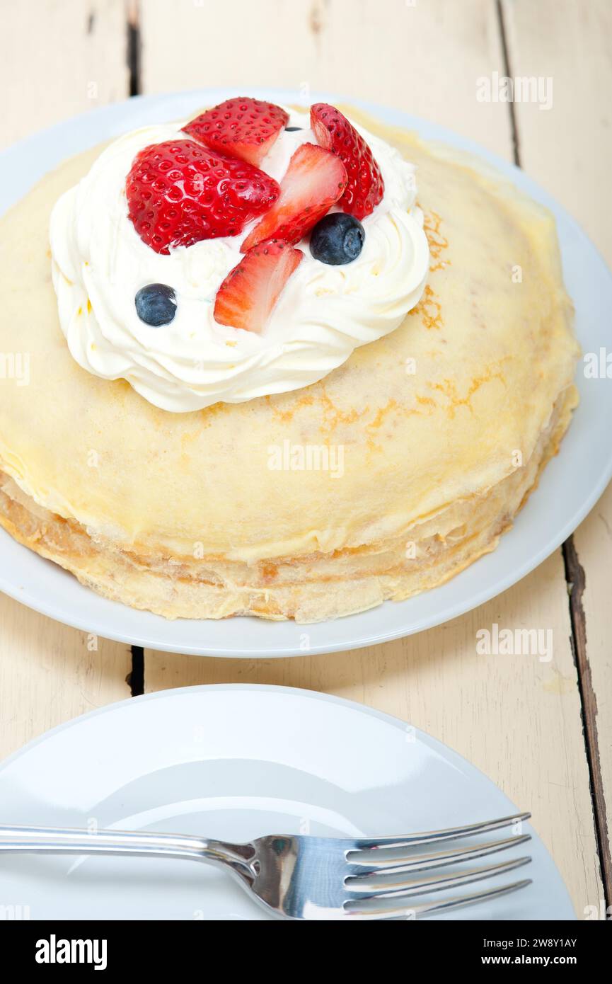 Crepe pancake cake with whipped cream and strawberry on top, food photography Stock Photo