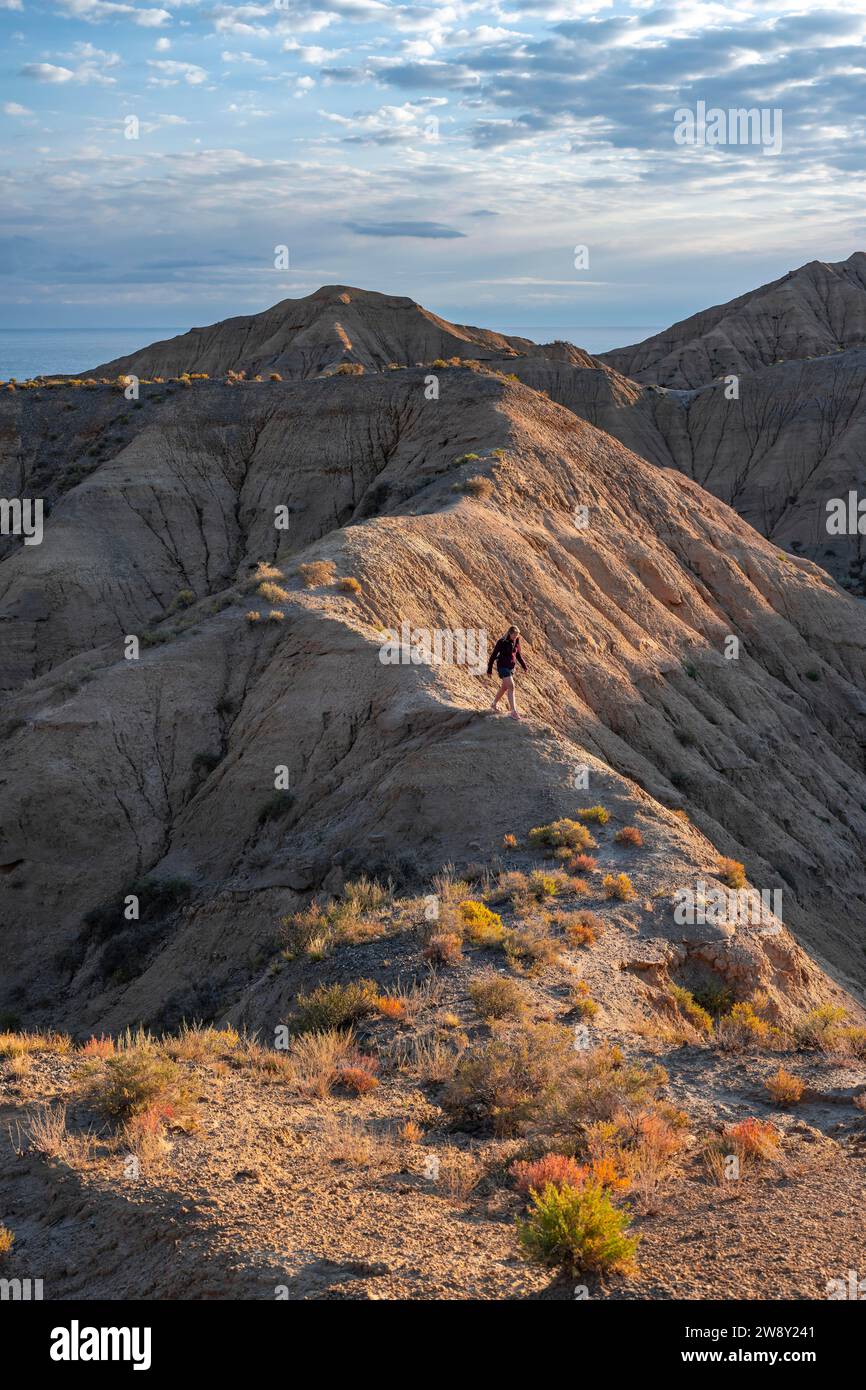 Tourist in a landscape of eroded hills at sunrise, Badlands, Canyon of ...