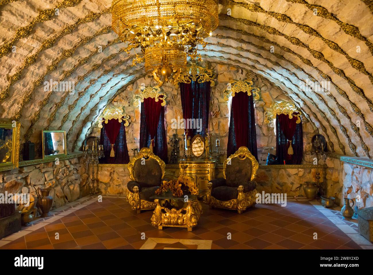 An opulently decorated room with throne chairs under a vaulted stone ceiling and a large chandelier, Rawadinovo Castle, Ravadinovo, Sosopol, Sozopol Stock Photo