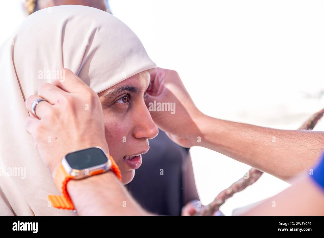 muslim female adjusting her hijab with a help  from other person Stock Photo
