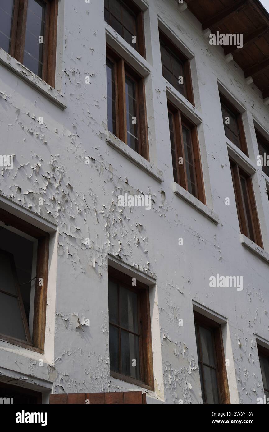 looks worn out from the windows of the building with peeling wall paint Stock Photo