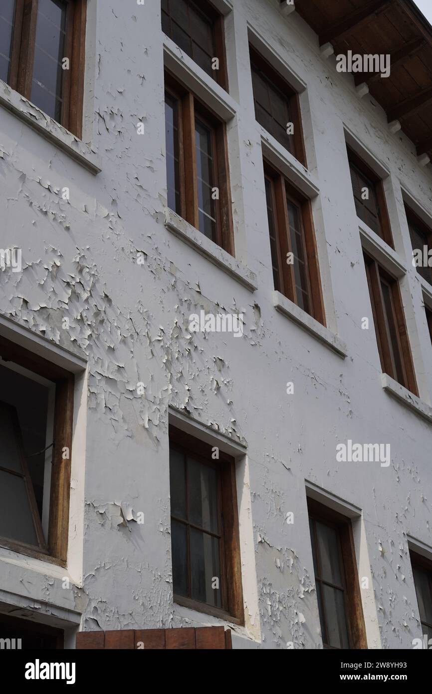 looks worn out from the windows of the building with peeling wall paint Stock Photo