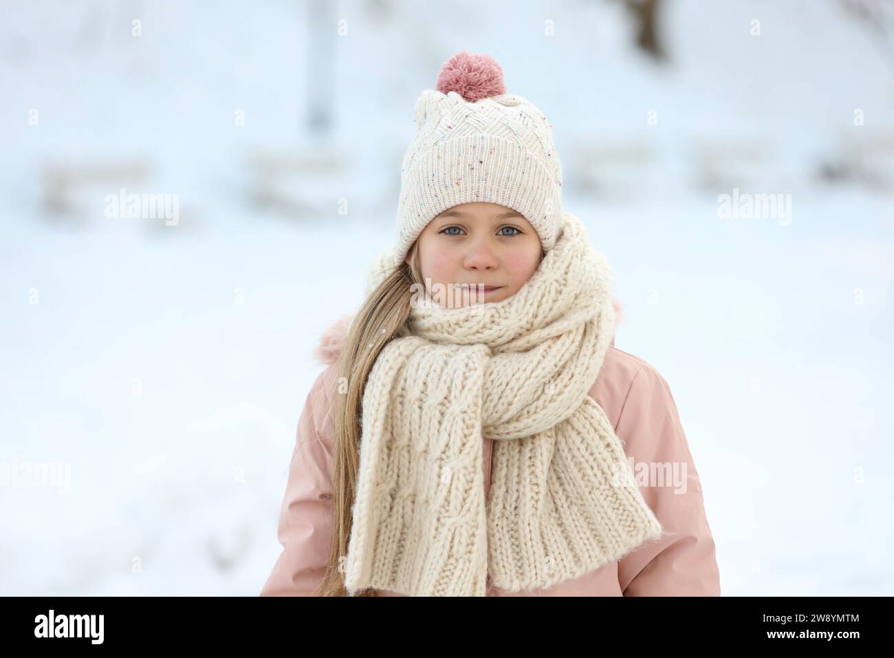 Little girl in winter clothes on the background of winter nature