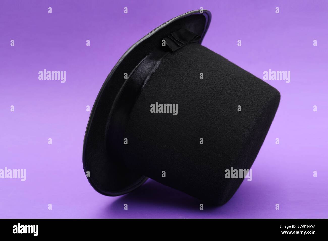 One magician top hat on violet background Stock Photo - Alamy