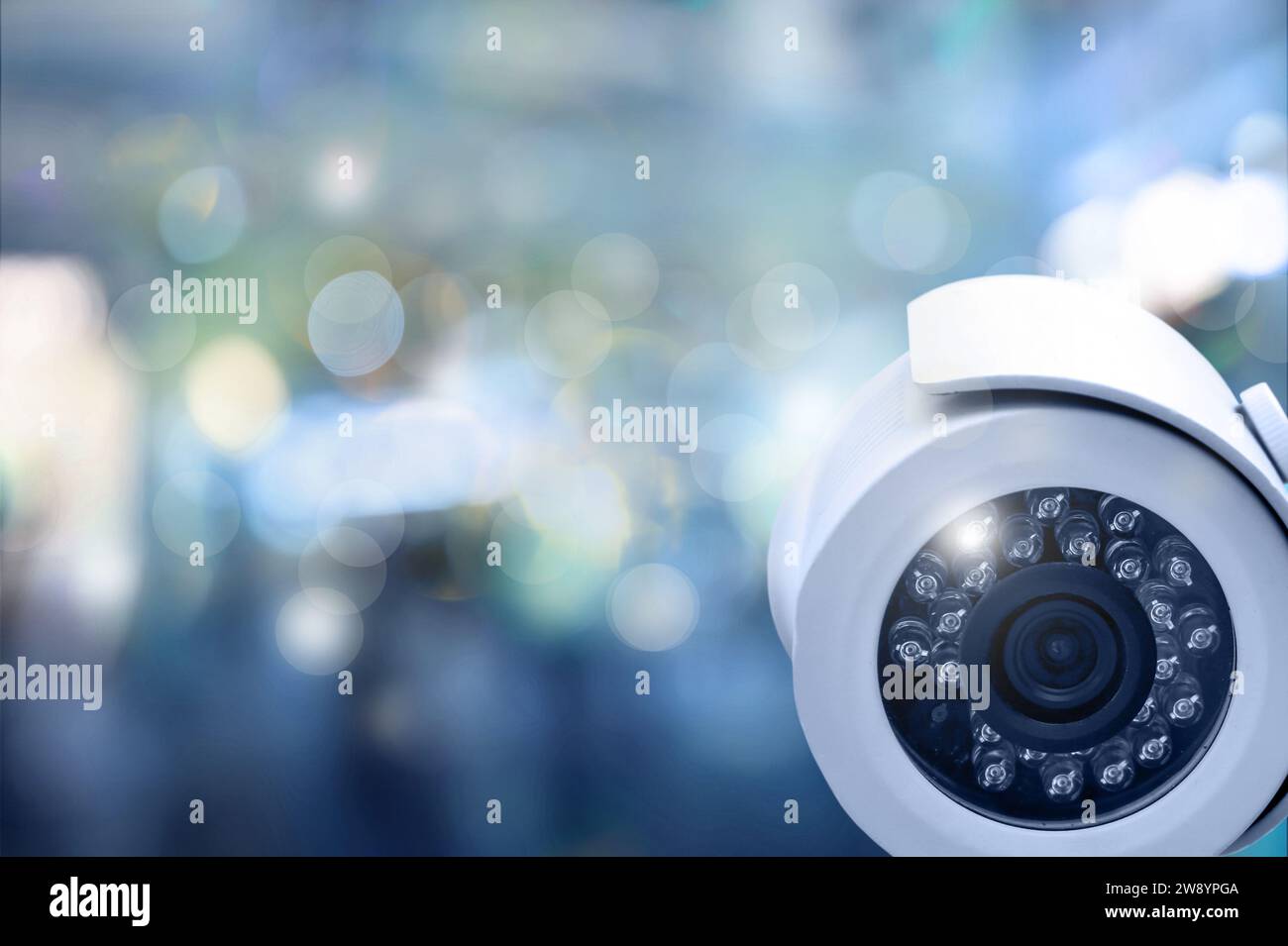 Modern security CCTV camera against blurred background, space for text