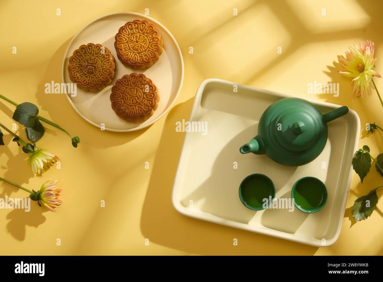 Minimal simplicity layout mooncakes, tea set and flowers on yellow ...