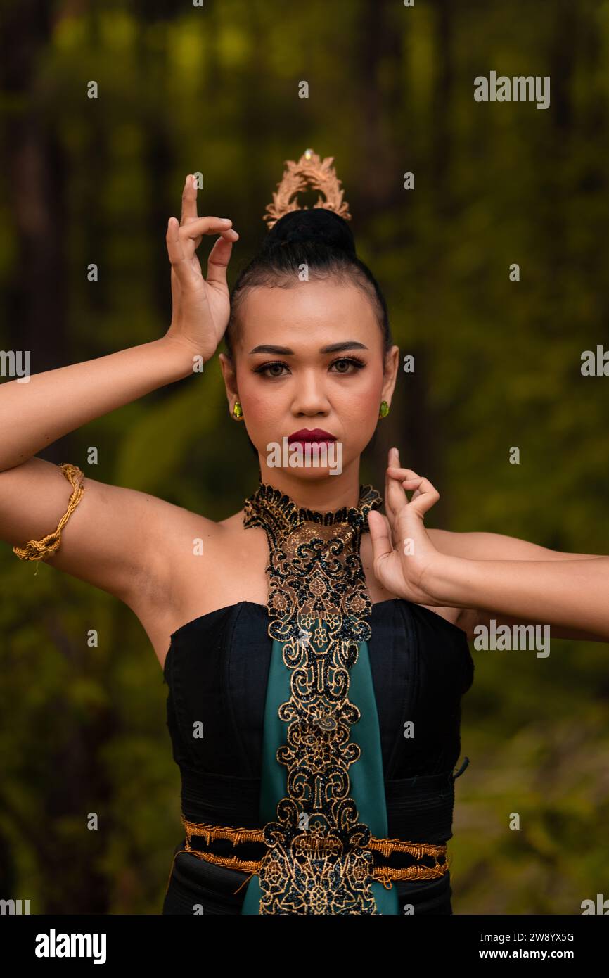 Brave Face of an Asian woman in a traditional green costume with golden accessories on her body during the competition in a dance festival in front of Stock Photo - Alamy Brave Face of an Asian woman in a traditional green costume with golden accessories on her body during the competition in a dance festival in front of Stock Photo - Alamy