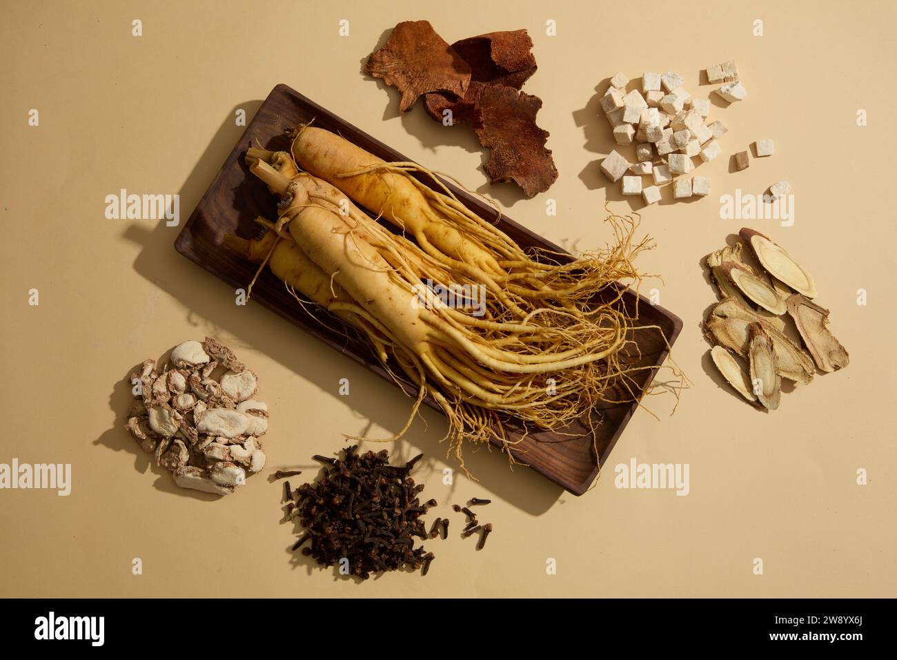 Image of fresh ginseng roots on wooden tray decorated with different