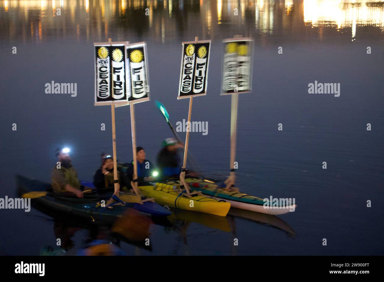 Oakland, California, USA. 22 Dec 2023. Bay Area Jews for Ceasefire Rally and Shabbat. Members of Jewish Voices for Peace gather for prayer to support Palestine and protest against bombing in Gaza and the killing of Gazans. Protesters in kayaks hold cease fire signs on Lake Merrit. Credit: Kristin Cato/Alamy Lives News Stock Photo