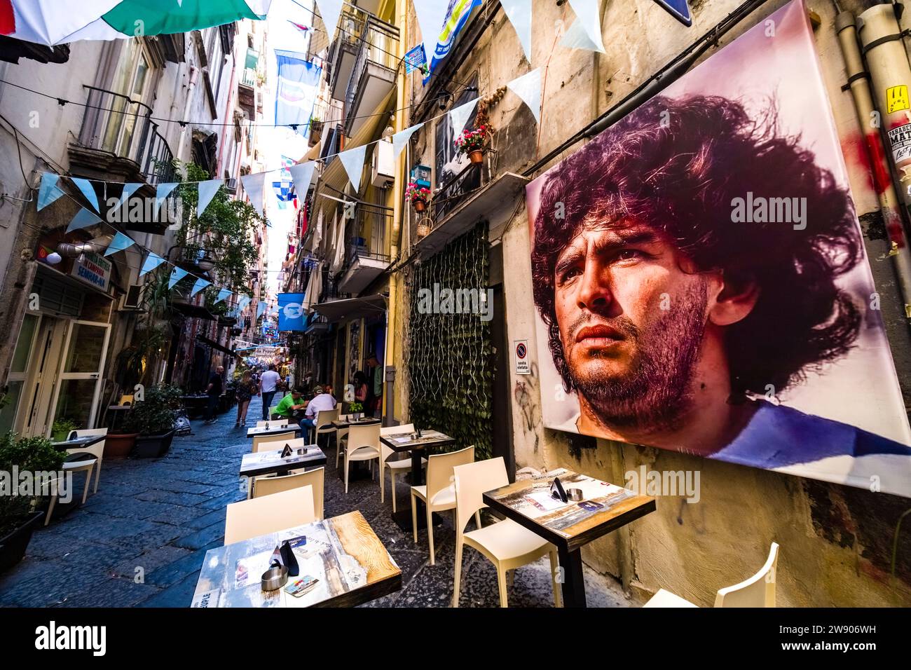 Large portrait of Diego Maradonna in the streets of Naples, adorned with flags of SSC Napoli, who have just won the 2023 Italian championship. Stock Photo