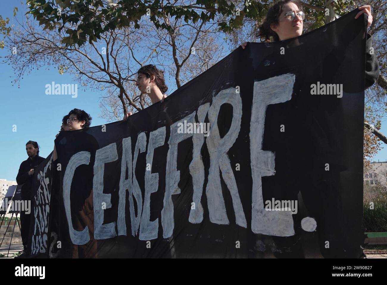 Israeli Jewish and Arab peace activists hold a banner that reads 'Ceasefire' as they gather for a vigil near the US consulate, calling for a ceasefire and mourning the 20,000 Palestinians killed by Israel’s bombardment of the Gaza Strip amid continuing battles between Israel and the militant group Hamas in Gaza on December 22, 2023 in Jerusalem, Israel Stock Photo