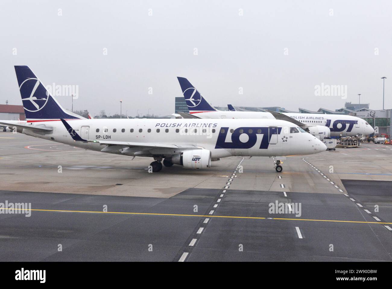 Embraer ERJ-170LR ERJ-170-100 LR at the Warsaw Airport apron or tarmac general view of LOT Polish airline aircrafts on a cloudy day Stock Photo