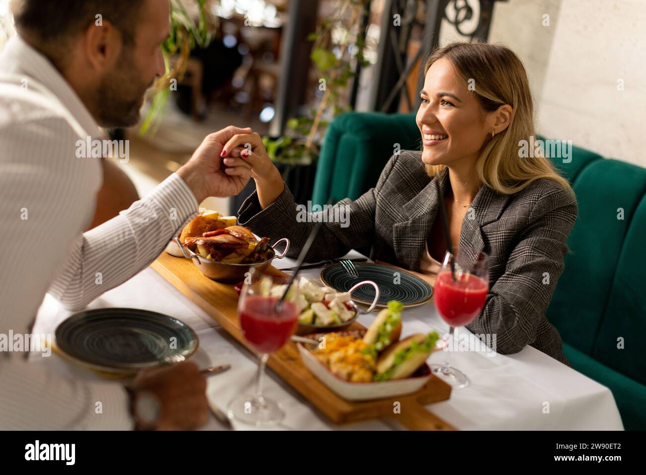 Young couple having a lunch and drinking fresh squeezed juice in the restaurant Stock Photo