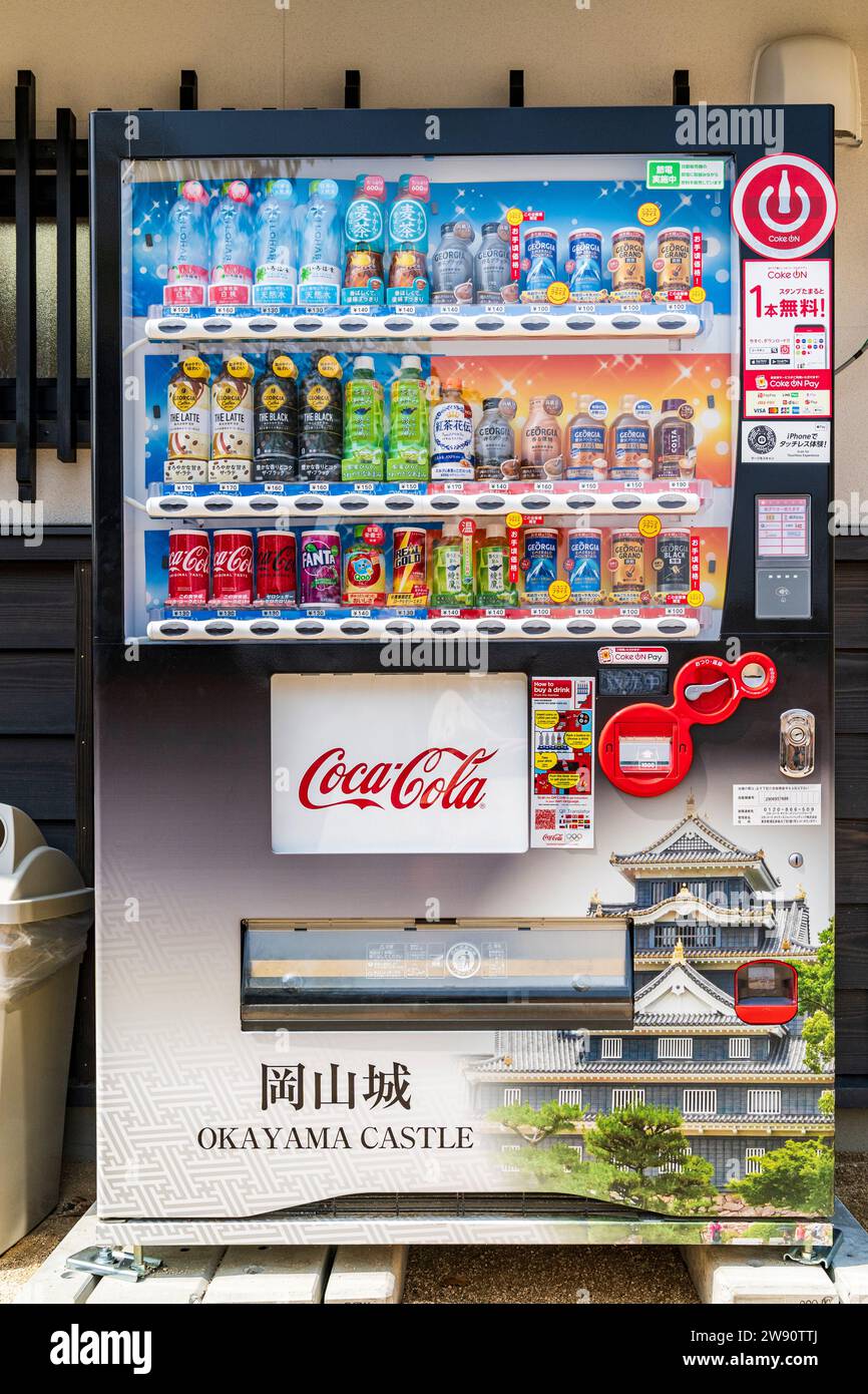 Japanese Coca-Cola vending machine at Okayama castle. The front of the machine features a picture of the black castle. Stock Photo