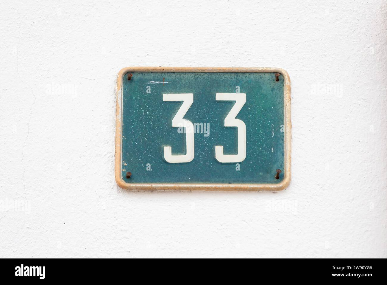 Finding Home: The Simple Elegance of a House Number Sign Displaying No. 33 Stock Photo