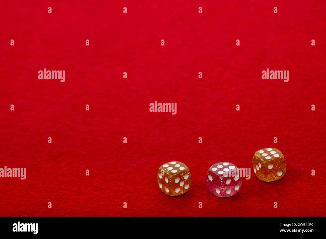 Three Dice with Value 6 on Red Velvet Playing Table - Gambling and Game Concept for Luck and Chance Games Stock Photo