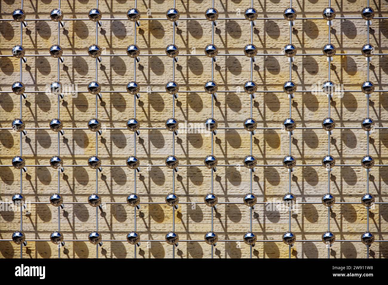 Play of light and shadows created by an artistic element on the facade of a modern building Stock Photo