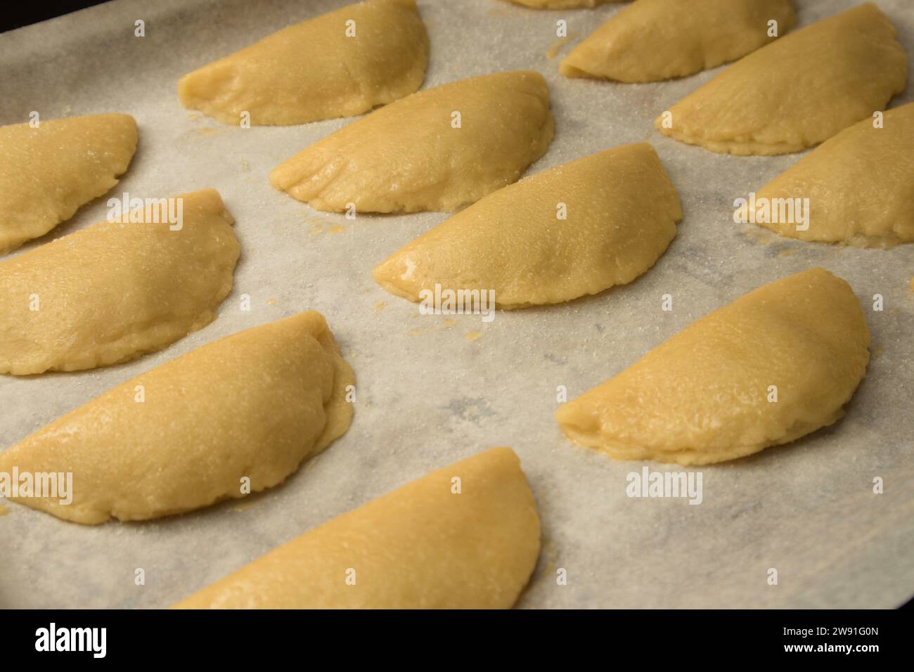 A baking tray with uncooked sweet potato pastries (pastissets) waiting to be baked. Typical Christmas sweet in Spain Stock Photo