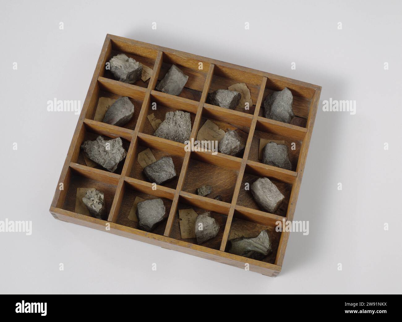 Box with Samples of Iron Ores and Slugs, anonymous, 1860 sample Rectangular open wooden drawer, divided into sixteen boxes, in which ten ore samples, five snails and two fragments of a snail. Most samples have small notes with the inscriptions, but identification of the samples with the inscriptions has now become impossible. Karlberg Palace wood (plant material). slag. paper Stock Photo