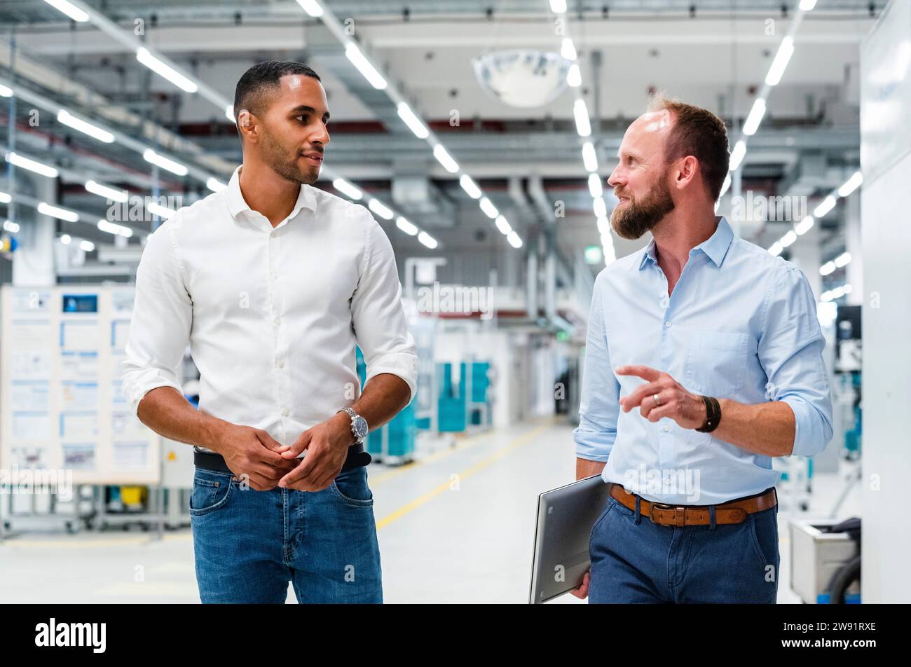 Two businessmen talking in a factory Stock Photo - Alamy